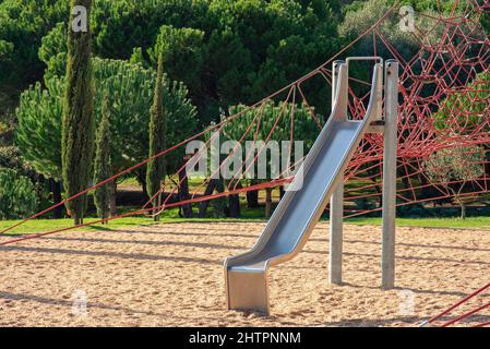 Metal children's slide on empty playground in the park Stock Photo