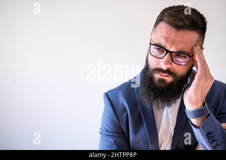 Portrait of businessman who is having headache. Copy space on image for your text or advert. Stock Photo