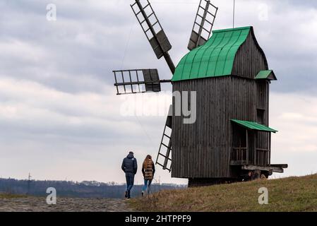 Pyrohovo (Pyrohiv) State Museum of Folk Architecture and Life of Ukraine. Couple walking near wooden windmills. Open air museum. Stock Photo