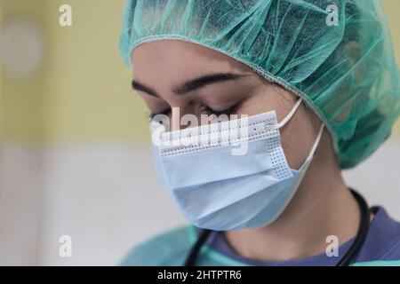 Portrait of sad and overwhelmed doctor wearing protective face mask, looking exhausted depressed and worried due to coronavirus outbreak. Emotional Stock Photo