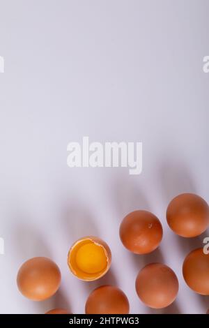 Close-up of brown eggs with one broken egg on table with blank space Stock Photo