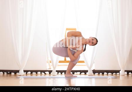 Sporty young man working out, standing in variation of Revolved Chair twist  Pose, Parivrtta utkatasana with extended arms Stock Photo - Alamy