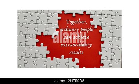 Top view of motivational quote on red cover - Together, ordinary people can achieve extraordinary results.With jigsaw puzzle missing pieces background Stock Photo