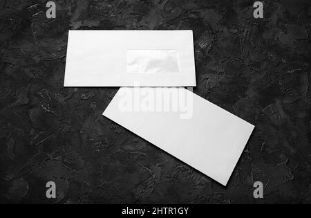 Blank paper envelopes on black stone background. Front and back side. Template for branding identity. Stock Photo