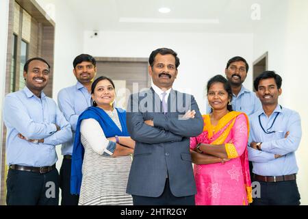 Diverse Indian corporate employees with arms crossed standing looking at camera at office - concept of teamwork, workforce, business development and Stock Photo