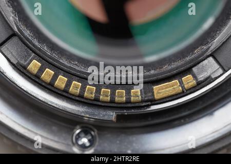 Worn gold-plated contacts on a photo lens mount. Macro photography Stock Photo