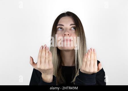 Muslim girl is rising hands and praying on white background. Copy and paste. Text space. Stock Photo