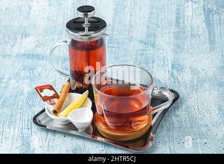 Hot winter tea served with a french press on a wooden table Stock Photo