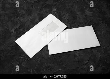 Two blank envelopes on black stone background. Back and front. Template for branding identity. Stock Photo