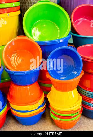 A collection of colourful plastic baskets for sale in a market place Stock Photo