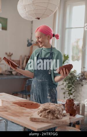 Female ceramist working with raw clay in pottery studio Stock Photo