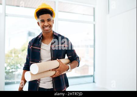 I turn empty spaces into awesomeness. Portrait of a young man and woman holding a blueprint in a modern office. Stock Photo