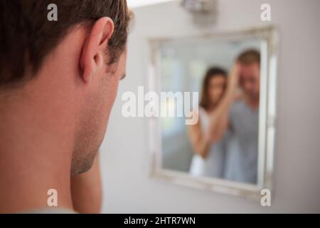 Feeling down and despondent. Shot of a distraught man being comforted by his wife at home. Stock Photo