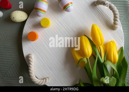 Easter eggs and yellow tulips on the table Stock Photo