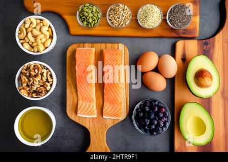Overhead View of Fresh Omega-3 Rich Foods: A variety of healthy foods like fish, nuts, seeds, fruit, vegetables, and oil rich in omega-3 nutrients Stock Photo