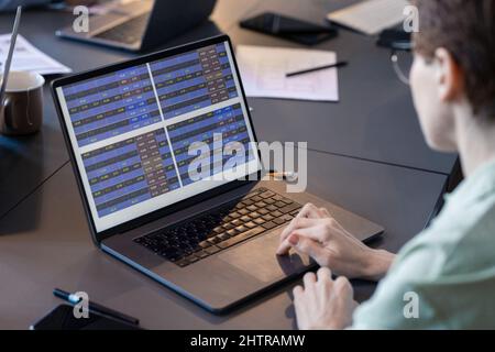 Close-up of businesswoman working online with program using her laptop during meeting at the table Stock Photo