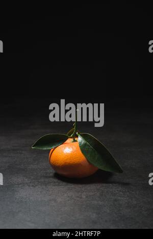 Fresh mandarin with leaves on dark background Stock Photo