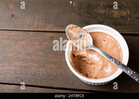 Chocolate mousse served in ramekin bowl with spoon on table with blank space Stock Photo