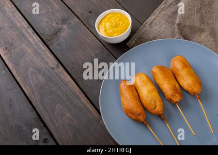 High angle view of corn dogs served in plate by mustered sauce in bowl on table Stock Photo