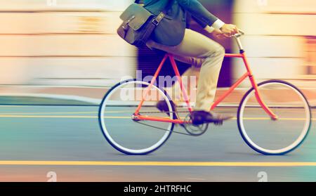 Speeding through the streets. Cropped shot of a man riding his bicycle through the city. Stock Photo