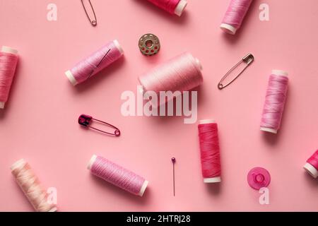 Composition with thread spools on color background Stock Photo