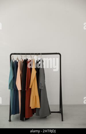 Black minimalistic rack with eco linen clothes on white backgrou Stock Photo