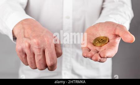 Businessman hand closeup holding bitcoin. Focus with coin. Manipulation, trading and transaction with cryptocurrency concept. High quality photo Stock Photo