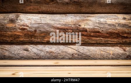 Empty wooden deck table in perspective. Rough wood tree trunk wall background. Stock Photo