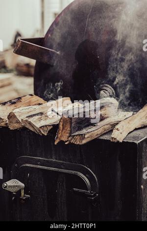 Vertical shot of a metal grilling stand with wood logs on top Stock Photo