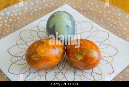 Stockholm, Sweden - April 7, 2021: Three eastern eggs in different colors on paper napkin with special pattern Stock Photo