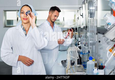 Two researchers in white coat checking wine acidity in laboratory Stock Photo