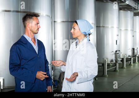 Two young winery workers in uniform . Stock Photo