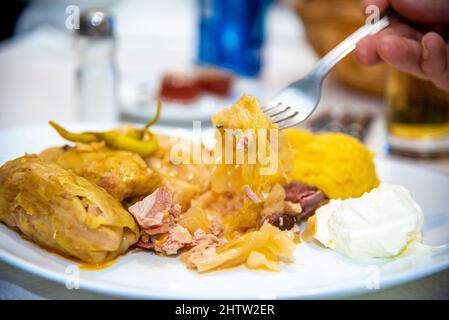 Closeup of a sarmale with polenta, sour cream, ribs, and hot peppers in a restaurant Stock Photo
