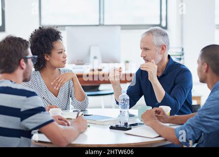 Discussing options. Shot of a group of designers at work in an office. Stock Photo