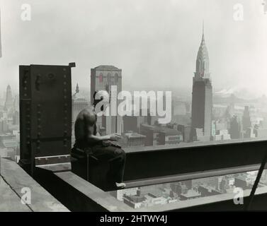 Art inspired by Empire State Building, 1930s, Gelatin silver print, 10.0 x 12.2 cm (3 15/16 x 4 13/16 in.), Photographs, Lewis Hine (American, 1874–1940), Hine took to great heights for this well-known photograph of a construction worker on the Empire State Building taking a break to, Classic works modernized by Artotop with a splash of modernity. Shapes, color and value, eye-catching visual impact on art. Emotions through freedom of artworks in a contemporary way. A timeless message pursuing a wildly creative new direction. Artists turning to the digital medium and creating the Artotop NFT Stock Photo