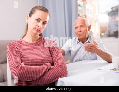 Upset daughter and senior man discussing, quarrel at home Stock Photo