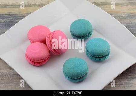 Raspberry and blueberry macarons snacks on white dessert plate on table Stock Photo