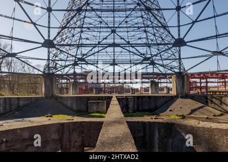 Low angle and selective focus view inside former gasometer, existing structure against blue sky. Stock Photo