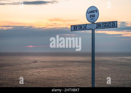 A summer sunset.The iconic signpost,established in the 1950s,a legendary Cornish icon,popular touristic landmark,used as starting and finishing point Stock Photo