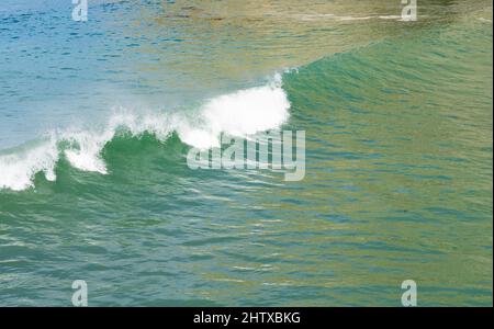 Surf waves with white water crests rolling in at Tolaga Bay, New Zealand. Stock Photo