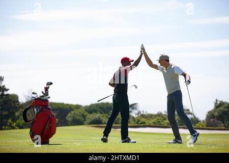 Good shot buddy. Shot of two happy men playing a game of golf. Stock Photo