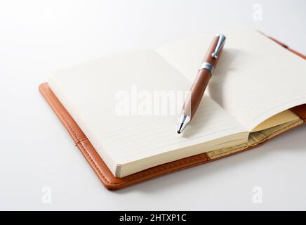 Leather notebook and pen placed against a white background. Business image. Stock Photo