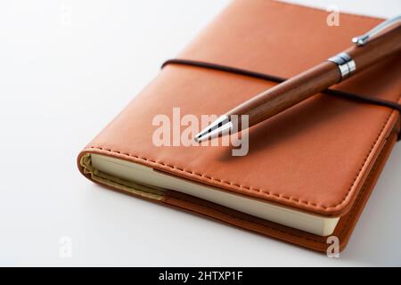 Leather notebook and pen placed against a white background. Business image. Stock Photo