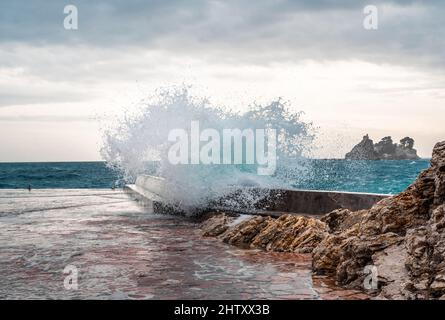 Big wave splash on pier. sea wave breaking on pier. Waves crashing on breakwaters. Waves and a storm at sea Stock Photo
