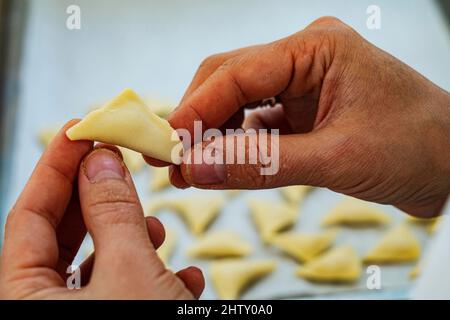 Hand, close-up, pelmeni, woman preparing traditional Ukrainian dumplings, authentic Ukrainian cuisine, Odessa specialities, Ukraine Stock Photo