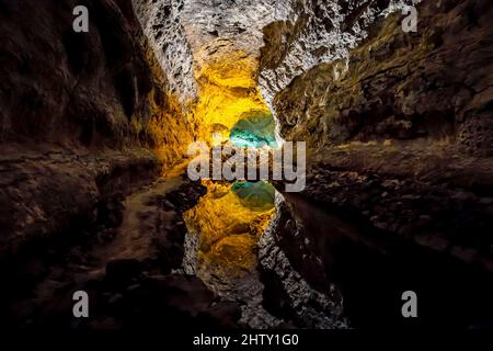 Colourfully illuminated areas of the Cueva de los Verdes, underground lake with reflection, Lanzarote, cave in lava rock, Lanzarote, Canary Islands Stock Photo