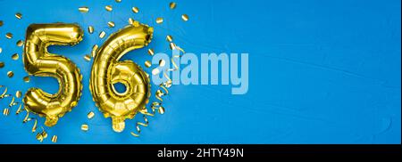 golden foil balloon number fifty six. Birthday or anniversary card with the inscription 56. blue concrete background. Anniversary celebration. Banner. Stock Photo