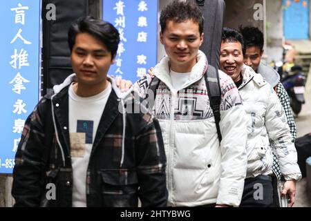 (220303) -- GUIYANG, March 3, 2022 (Xinhua) -- Bassist Peng Wanhai, guitarist Yang Zhi, lead singer Chen Kexing and drummer Chen Changhai (front to rear) walk out of a massage parlor in Guiyang, southwest China's Guizhou Province, March 1, 2022. A band named 'Fish Mint' consists of three massage therapists and a delivery man who were all born in the 1990s. Yet the delivery man is the only one who could see while the rest are with visual impairment. The members do their regular work during the day and gather around to play music in the band in the evening. The band is named after fish mint, a Stock Photo