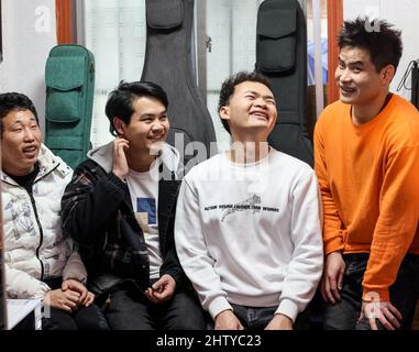 (220303) -- GUIYANG, March 3, 2022 (Xinhua) -- Lead singer Chen Kexing (1st L), guitarist Yang Zhi (2nd R), drummer Chen Changhai (1st R), and bassist Peng Wanhai (2nd L) take a rest at a massage parlor in Guiyang, southwest China's Guizhou Province, March 1, 2022. A band named 'Fish Mint' consists of three massage therapists and a delivery man who were all born in the 1990s. Yet the delivery man is the only one who could see while the rest are with visual impairment. The members do their regular work during the day and gather around to play music in the band in the evening. The band is name Stock Photo