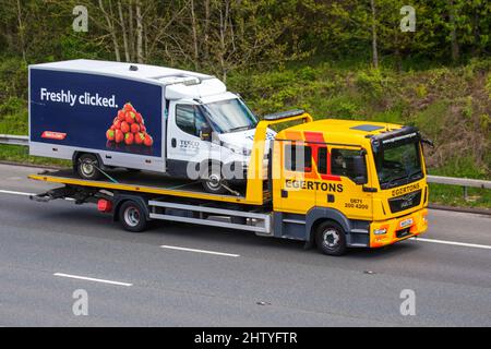 MAN 12.220 4X2 BL LX 4580CC DIESEL, driving on the M61 motorway UK carrying broken down Tesco on-line delivery grocery van. Stock Photo